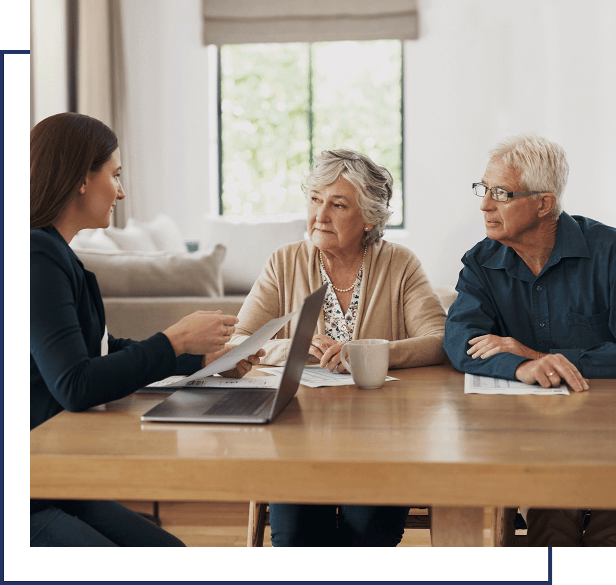 Woman consulting elderly couple at table.